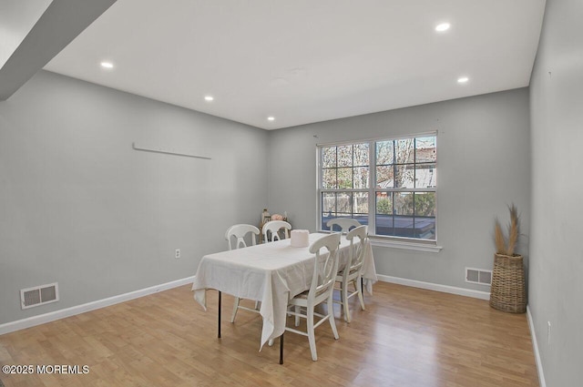 dining space featuring light wood finished floors, baseboards, and visible vents