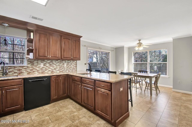 kitchen with dishwasher, a peninsula, a sink, and visible vents