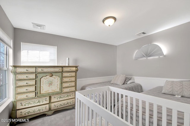 carpeted bedroom featuring visible vents