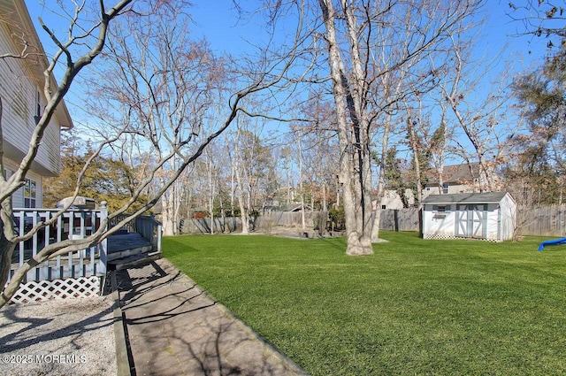 view of yard with an outbuilding, a fenced backyard, and a storage unit