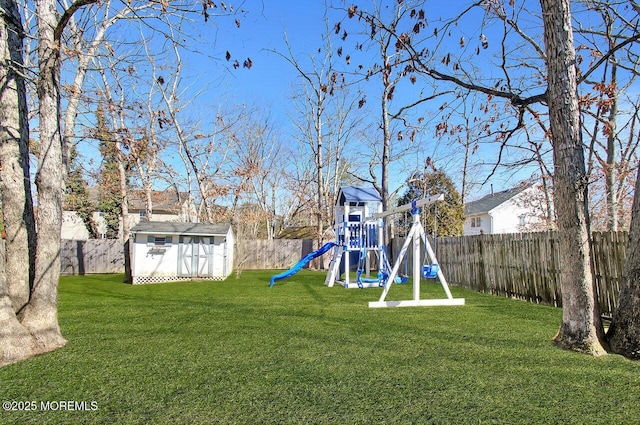 view of yard with an outbuilding, a playground, a fenced backyard, and a storage shed