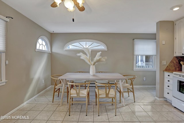 dining room with light tile patterned flooring, a ceiling fan, and baseboards