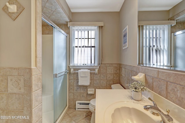 full bath featuring toilet, a baseboard heating unit, tile walls, a shower stall, and tile patterned floors