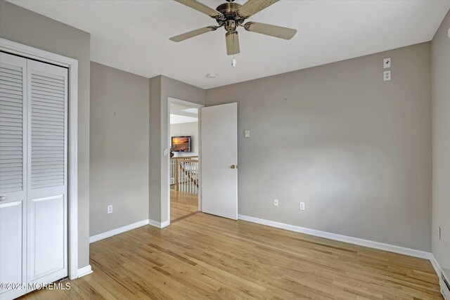 unfurnished bedroom with a closet, light wood-style flooring, and baseboards