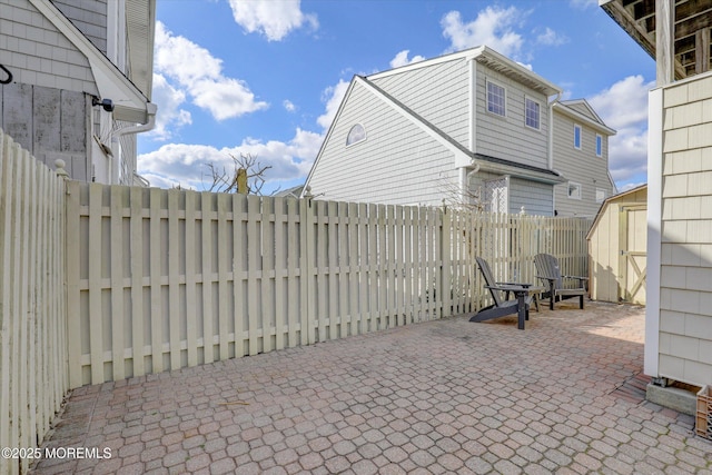 view of patio / terrace with a storage shed, a fenced backyard, and an outdoor structure