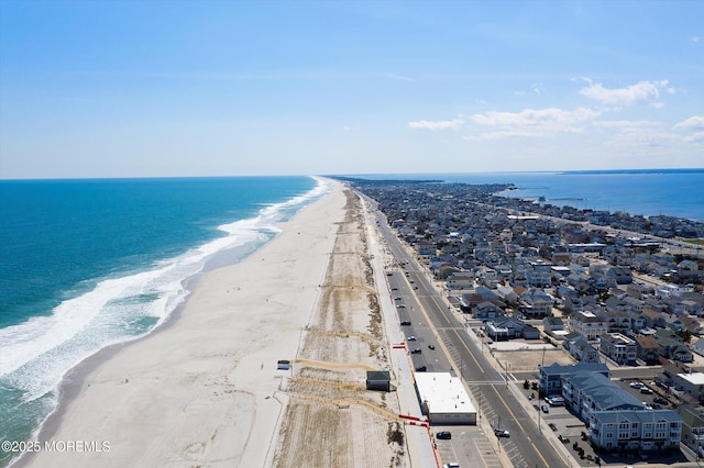 drone / aerial view with a beach view and a water view