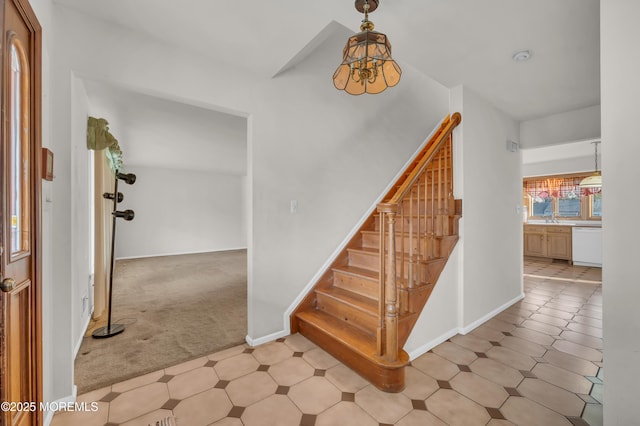 stairway featuring carpet flooring, baseboards, and an inviting chandelier