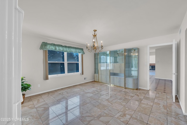 spare room with baseboards and an inviting chandelier