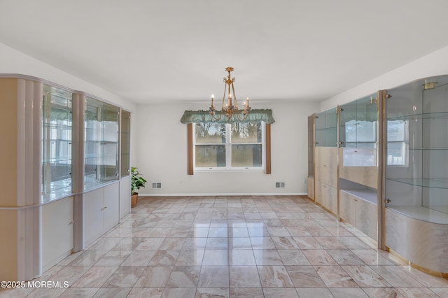 unfurnished room featuring baseboards, visible vents, and a chandelier