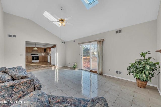 living area featuring a skylight, visible vents, ceiling fan, and light tile patterned flooring