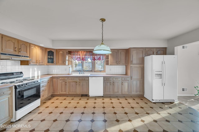 kitchen featuring under cabinet range hood, white appliances, a sink, light countertops, and backsplash