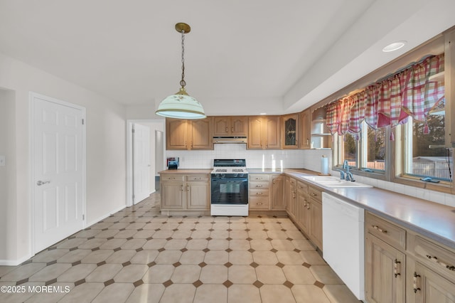 kitchen featuring pendant lighting, backsplash, a sink, white appliances, and under cabinet range hood