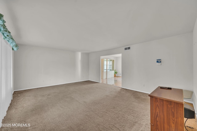 carpeted empty room featuring baseboards and visible vents