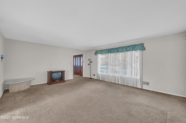 unfurnished living room with baseboards, visible vents, and carpet flooring