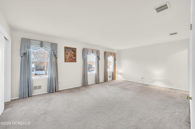 carpeted spare room with visible vents and a wealth of natural light