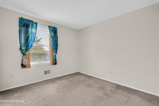 unfurnished room featuring carpet floors, visible vents, and baseboards