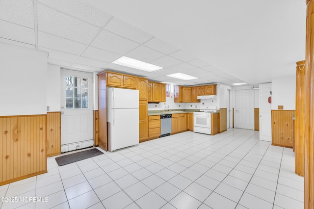 kitchen featuring white appliances, wainscoting, wood walls, a paneled ceiling, and under cabinet range hood