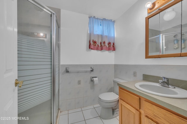 bathroom with tile patterned flooring, a shower stall, and tile walls