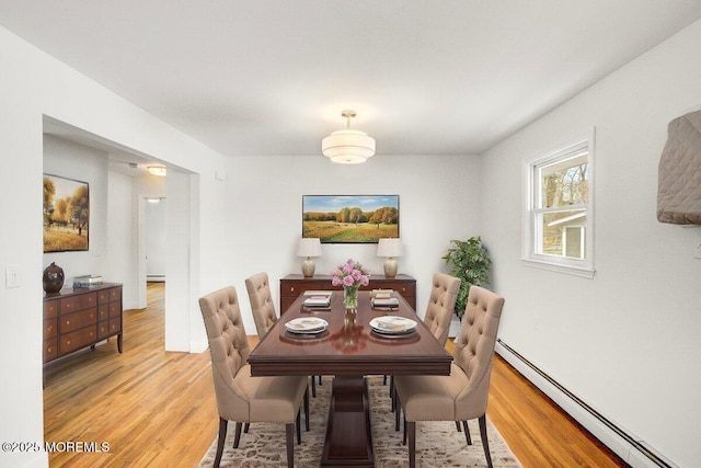 dining room featuring light wood finished floors and baseboard heating