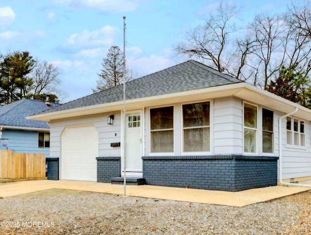 view of front of home featuring brick siding, fence, concrete driveway, roof with shingles, and an attached garage