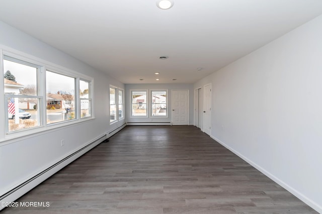 unfurnished room with baseboards, a baseboard heating unit, wood finished floors, and recessed lighting