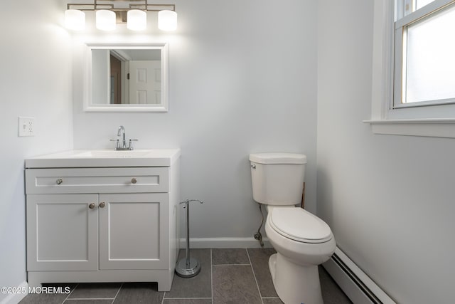 bathroom with baseboards, toilet, tile patterned flooring, baseboard heating, and vanity