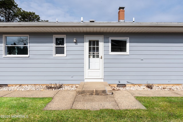 property entrance featuring crawl space and a chimney