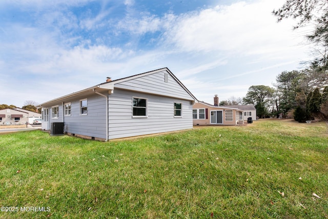 back of property with a lawn and central air condition unit