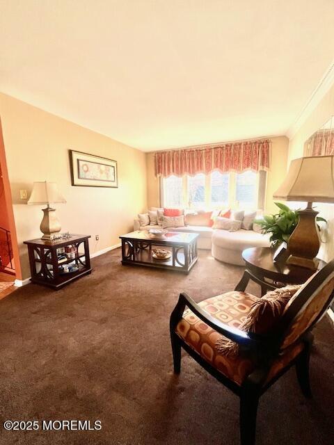 carpeted living room with crown molding and baseboards