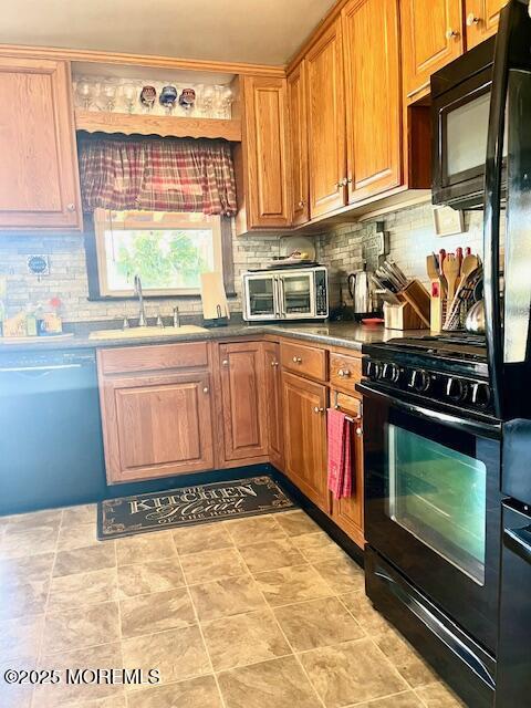 kitchen with tasteful backsplash, a toaster, a sink, and black appliances