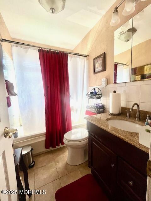 bathroom with vanity, tasteful backsplash, tile patterned flooring, and toilet