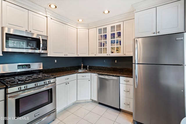 kitchen featuring white cabinetry, stainless steel appliances, a sink, and light tile patterned flooring