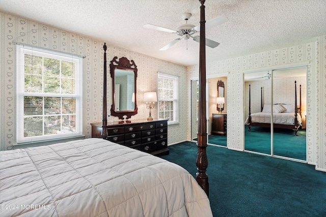 carpeted bedroom featuring multiple closets, a ceiling fan, a textured ceiling, and wallpapered walls