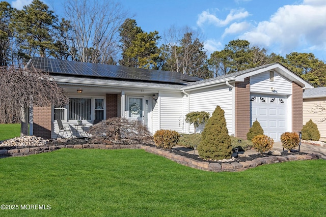 single story home with a garage, roof mounted solar panels, a front lawn, and brick siding