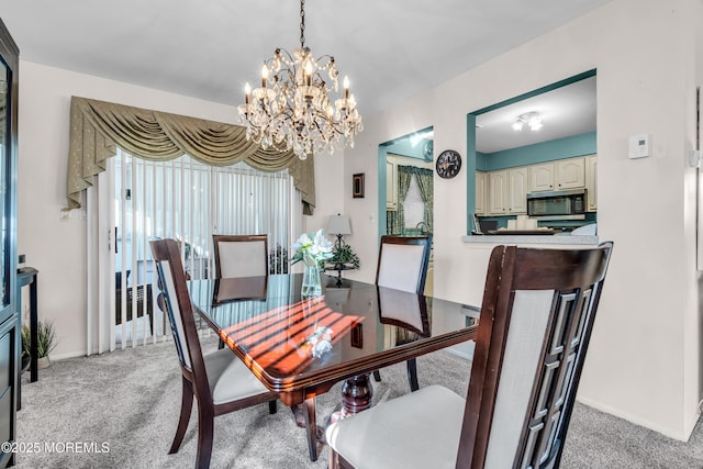 dining space with baseboards, a notable chandelier, and light colored carpet