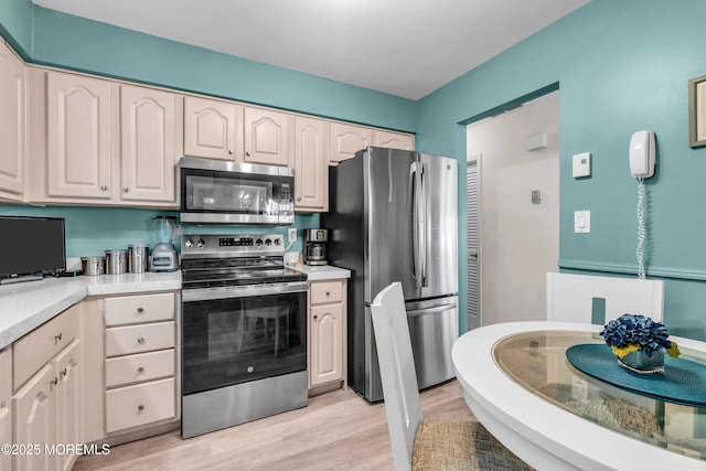 kitchen featuring light wood-style floors, appliances with stainless steel finishes, and light countertops