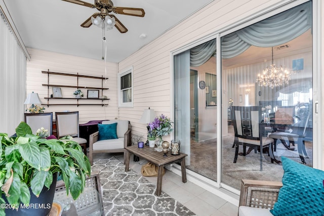 sunroom / solarium featuring ceiling fan with notable chandelier