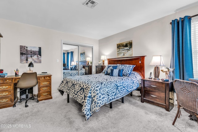 carpeted bedroom featuring a closet and visible vents