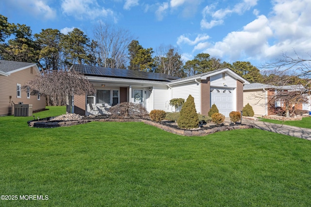 ranch-style home featuring a garage, central air condition unit, roof mounted solar panels, a front lawn, and brick siding