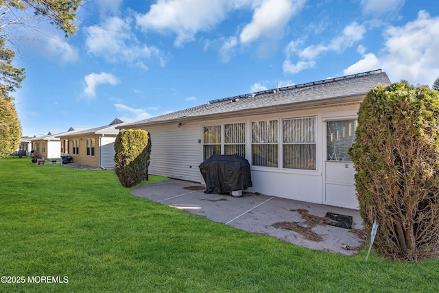 back of property with a lawn and a patio