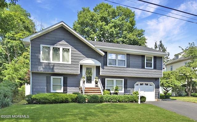 split foyer home featuring a garage, aphalt driveway, and a front yard