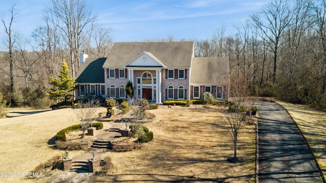 greek revival house featuring a chimney