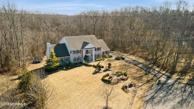 birds eye view of property featuring a forest view