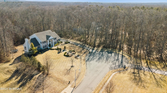 birds eye view of property featuring a view of trees