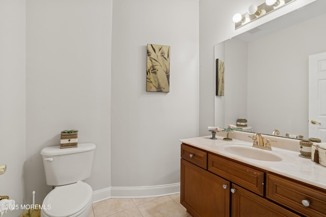 half bathroom with baseboards, vanity, toilet, and tile patterned floors