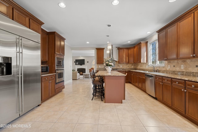 kitchen featuring light tile patterned floors, a sink, decorative backsplash, and built in appliances