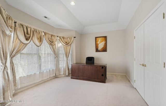 carpeted home office with a tray ceiling, visible vents, and baseboards