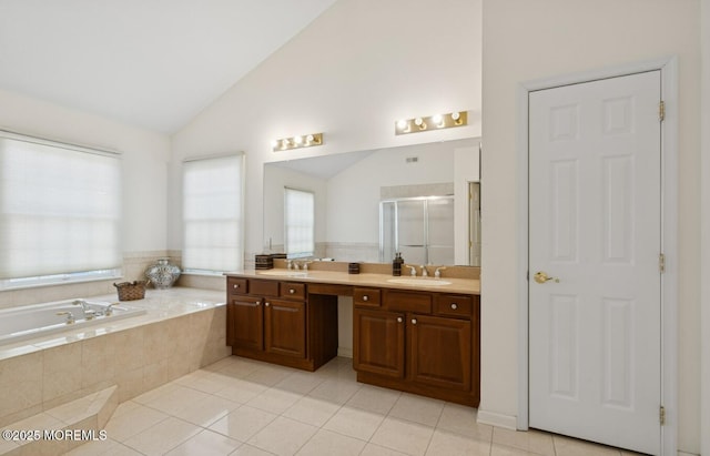 bathroom with lofted ceiling, a garden tub, a sink, and a stall shower