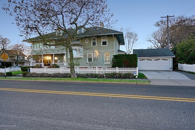 view of front facade with an attached garage, a fenced front yard, and concrete driveway