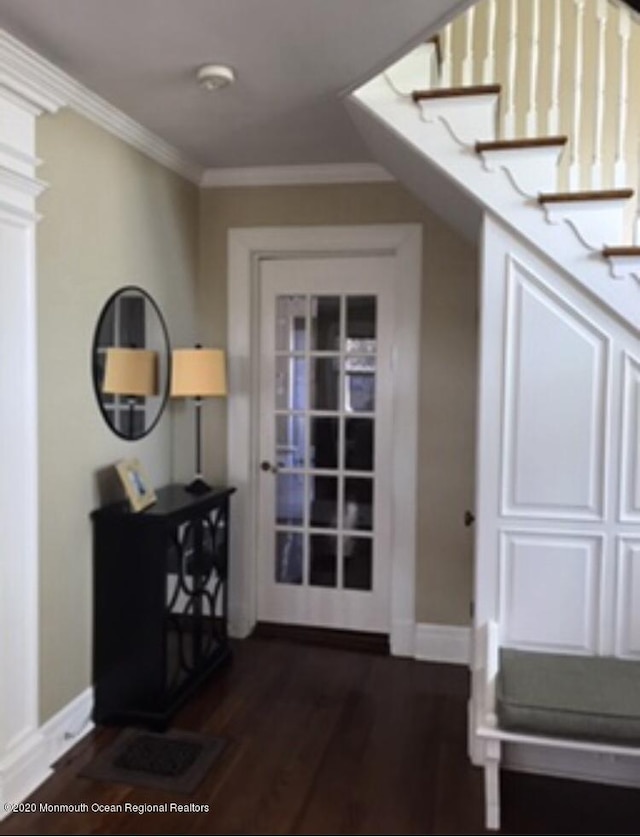 doorway with dark wood-style floors, baseboards, stairway, and crown molding